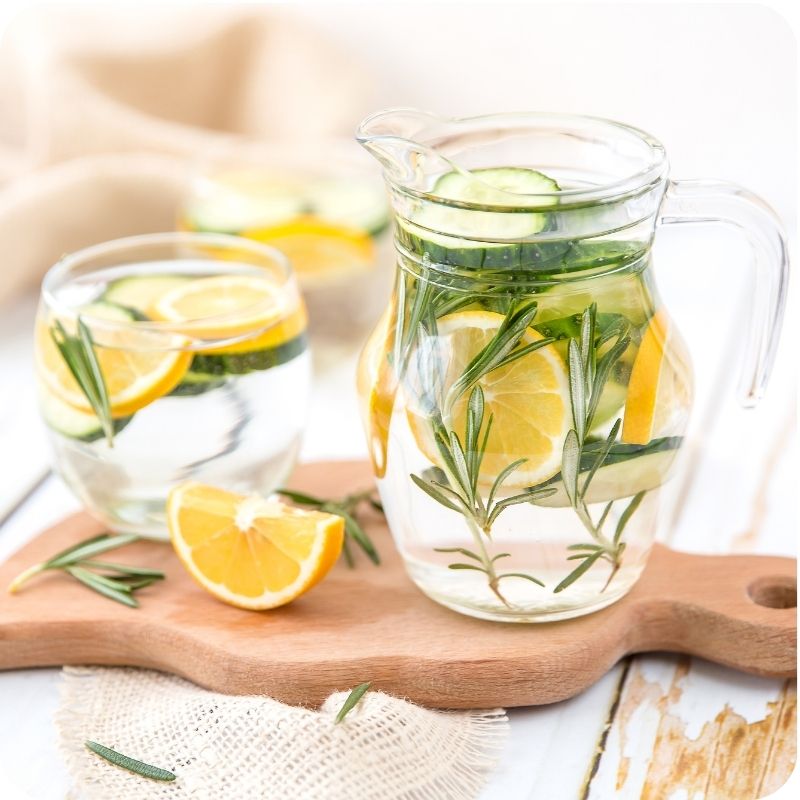 Image of a glass with water and lemons in it.