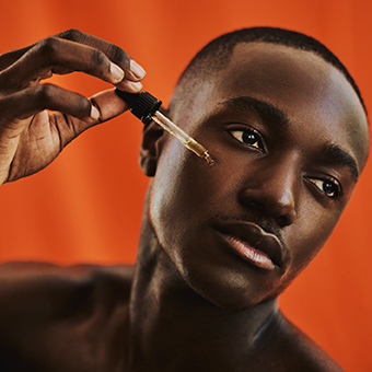 Image of a male using a serum for skin care.