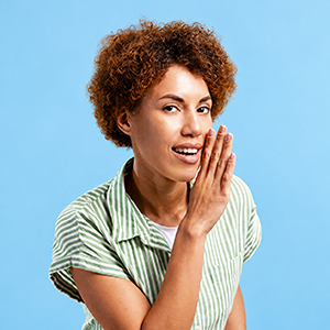 Woman whispering secret, communicating confidentially, sharing gossip on blue background