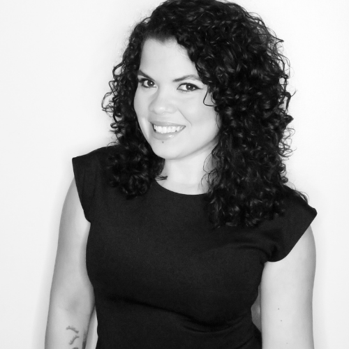 Black and white image of woman with dark hair smiling at camera 