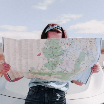 Woman taking a roadside pitstop to review a map