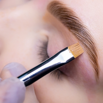 Esthetician performing eyebrow lamination service