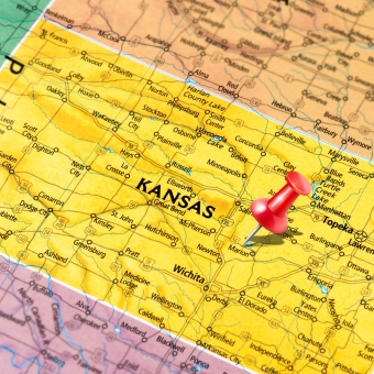 Map or Kansas and surrounding border states with a push pin in Kansas