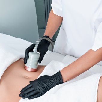 Esthetician performing body contouring on a client's stomach