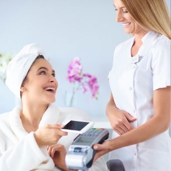 Client completing a point of sale transaction with an esthetician