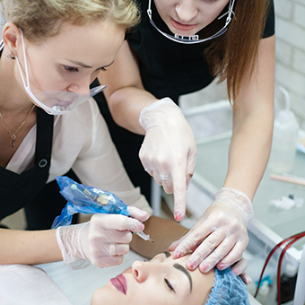 Esthetics students being taught an esthetics service by instructor