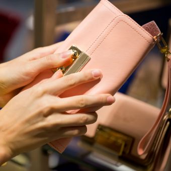 Woman opening a peach colored wallet