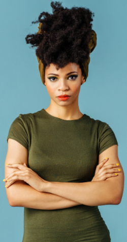 Woman in green shirt with a serious facial expression and arms crossed