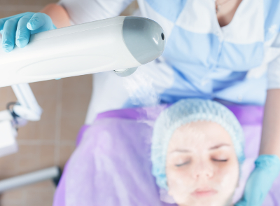 An esthetician uses a facial steaming machine during their client's facial. 