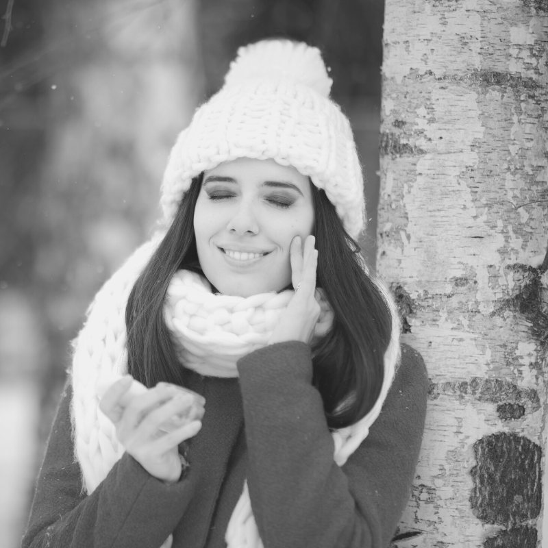 woman wearing a sweater and feeling her skin