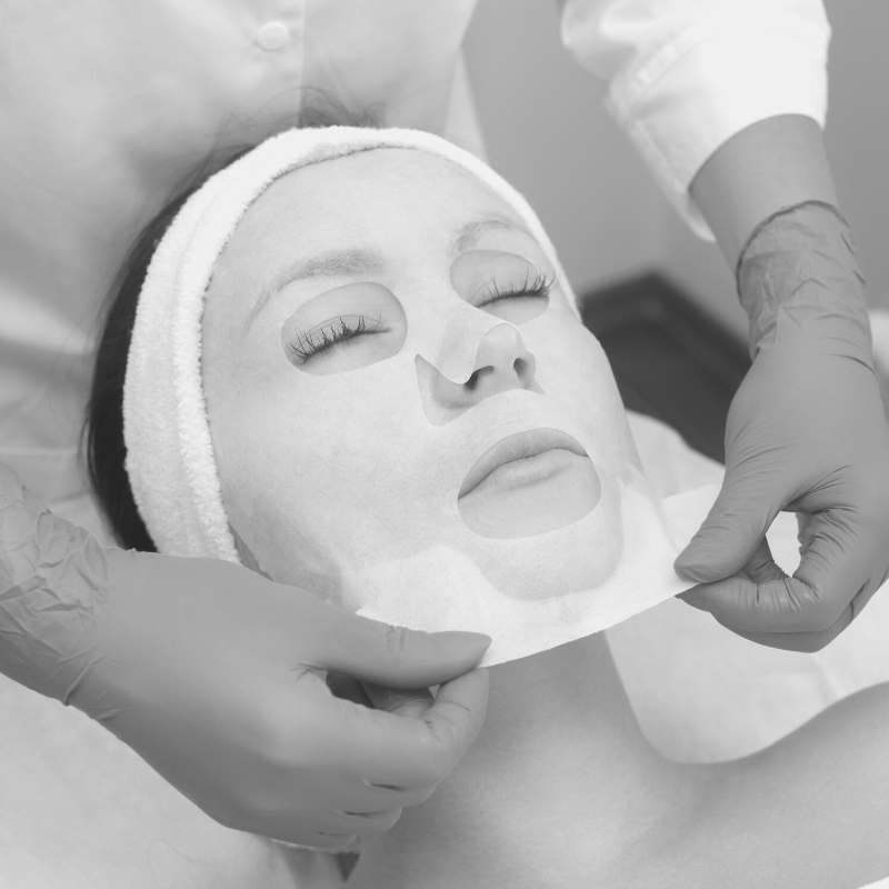 sheet mask being removed by esthetician