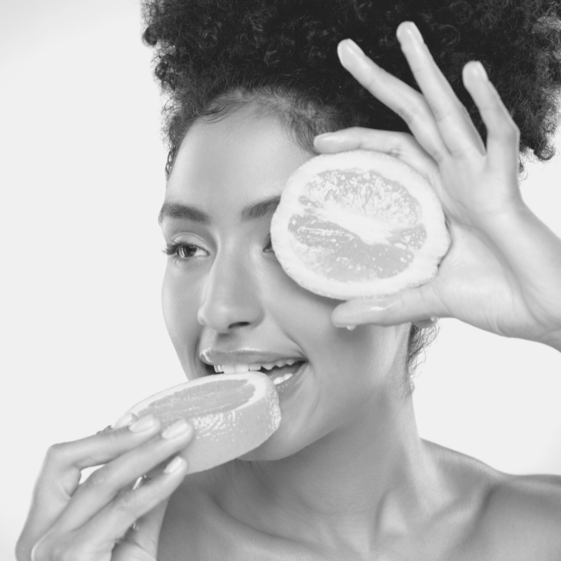 Girl holding a lemon to her face