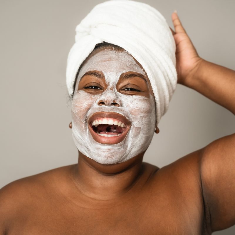 woman smiling with towel on her head