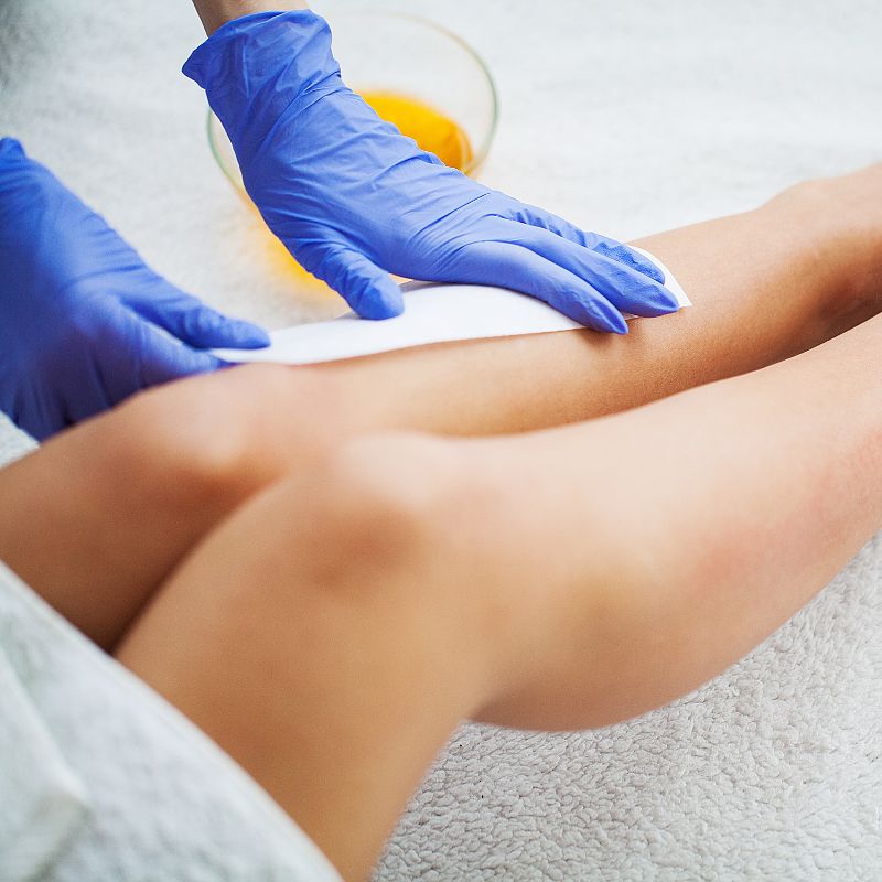 esthetician waxing client legs