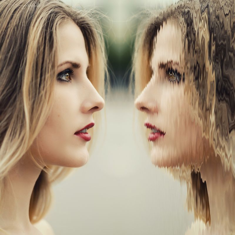 woman looks at her reflection