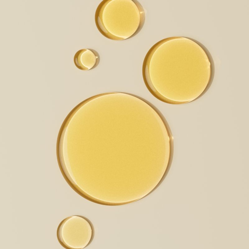 image of oil drops against a pink background.