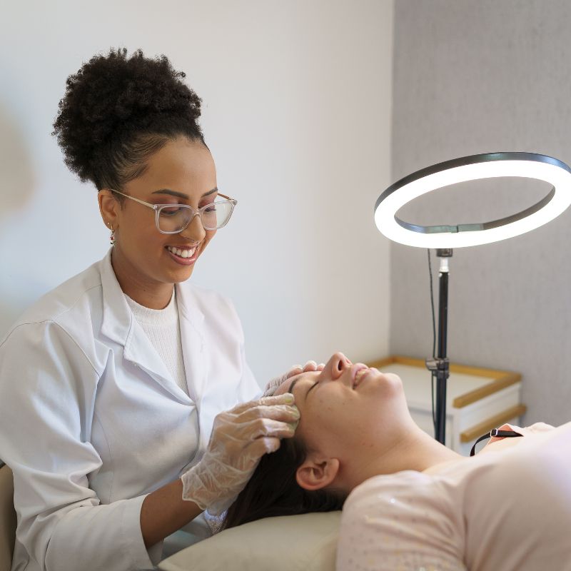 Image of a person under a light ring receiving a fascial treatment.