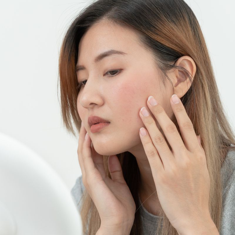 Image of a person touching their face.