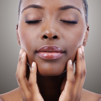 Image of a person holding their hands to their face with eyes closed.