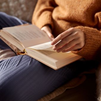 Image of a person sitting and reading a book.