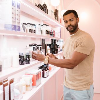 Image of a man standing at a cosmetics counter.