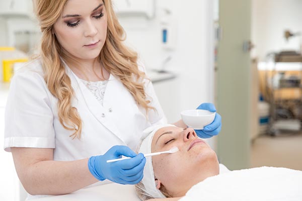 Esthetician applying a facial chemical peel