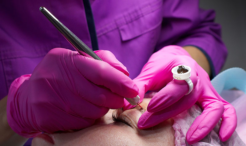 Esthetician performing microblading on a client