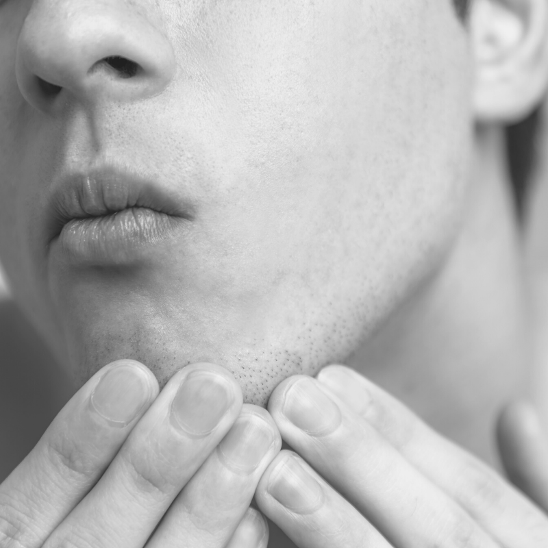Man examining the skin on his chin