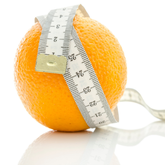 Skin Deep Magazine - The Fight Against Cellulite. Picture of an orange with a measuring tape wrapped around it.