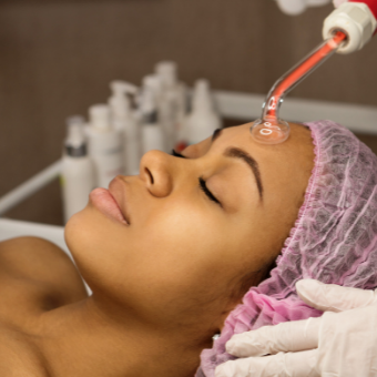 Woman receives high frequency treatment on forehead