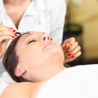 esthetician shapes client's brow