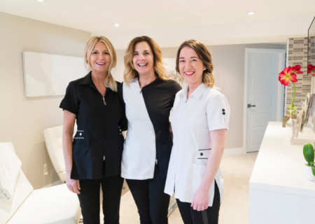 Proud business owner and estheticians wearing branded spa uniform