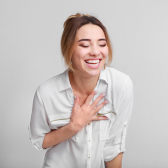 girl smiling and holding her hands to her chest in gratitude