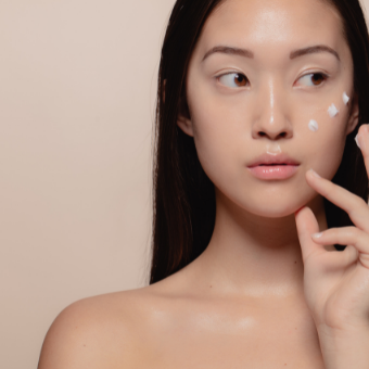 Woman dots her face with cream