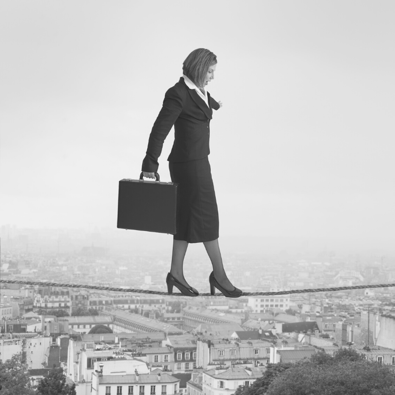 Confident business woman walking a tightrope